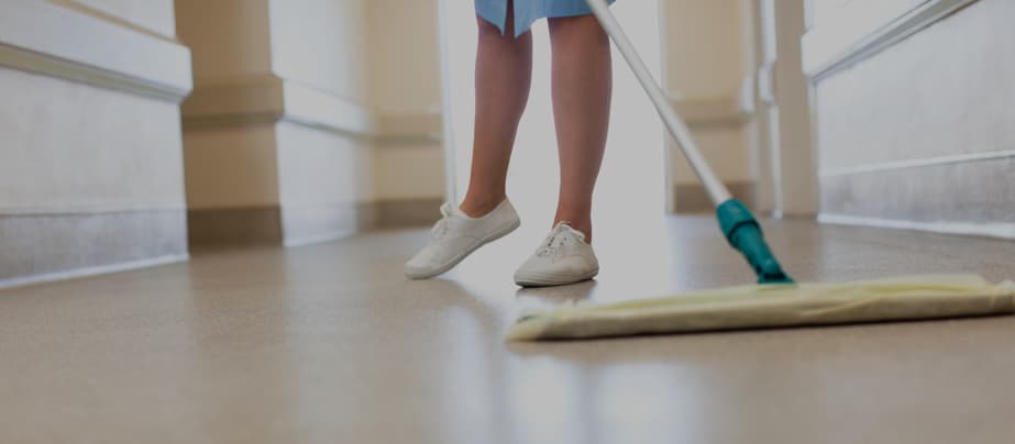 A person cleaning the floor at a long-term care facility.